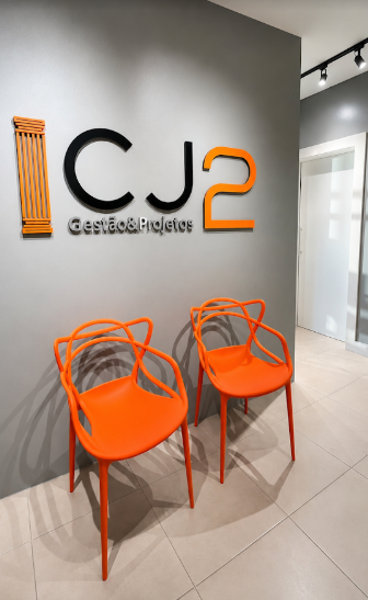 Recepção da CJ2 com logotipo na parede e poltronas laranja